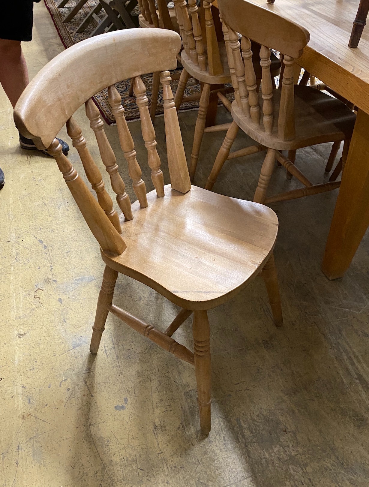 A modern bleached wood kitchen table, length 210cm, height 85cm with a set of eight beech kitchen chairs